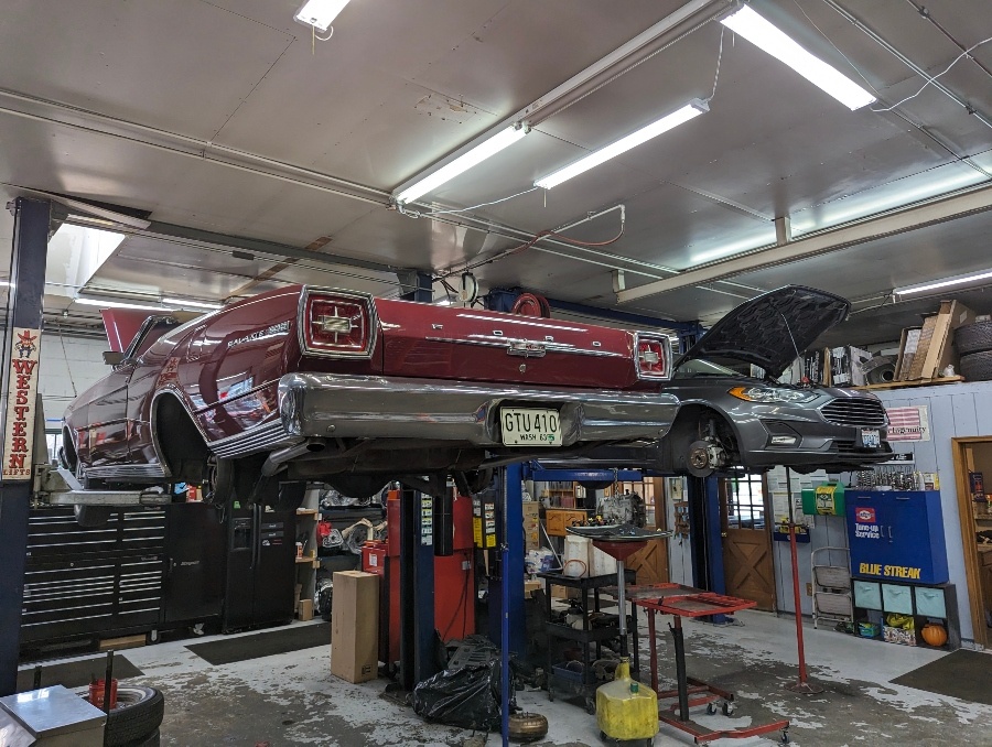 A classic Ford Galaxie 500 and a late-model Ford up on the lifts