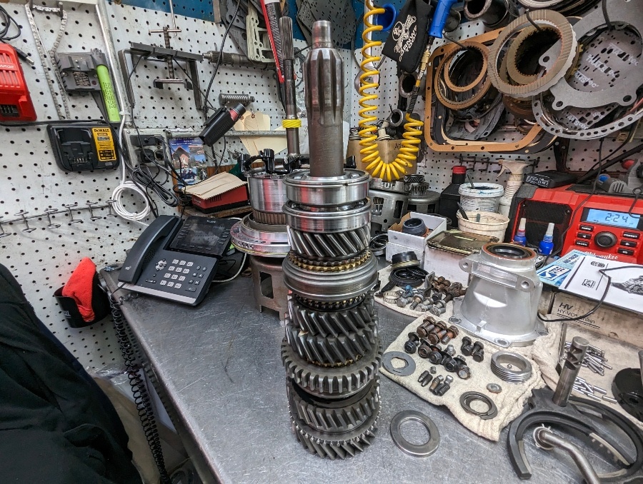 A manual transmission gear cluster stacked on the rebuild bench